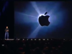 Steve Jobs on stage with a projector screen showing the apple logo